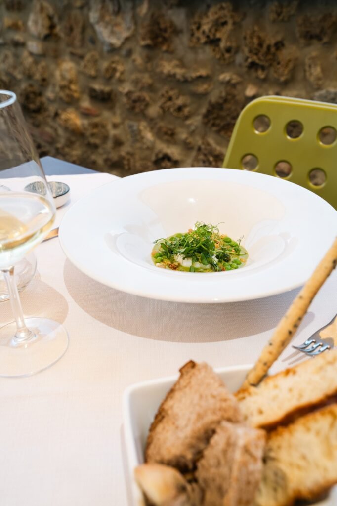 Antipasto di verdura con bicchiere di vino bianco e cestino di pane e grissini
