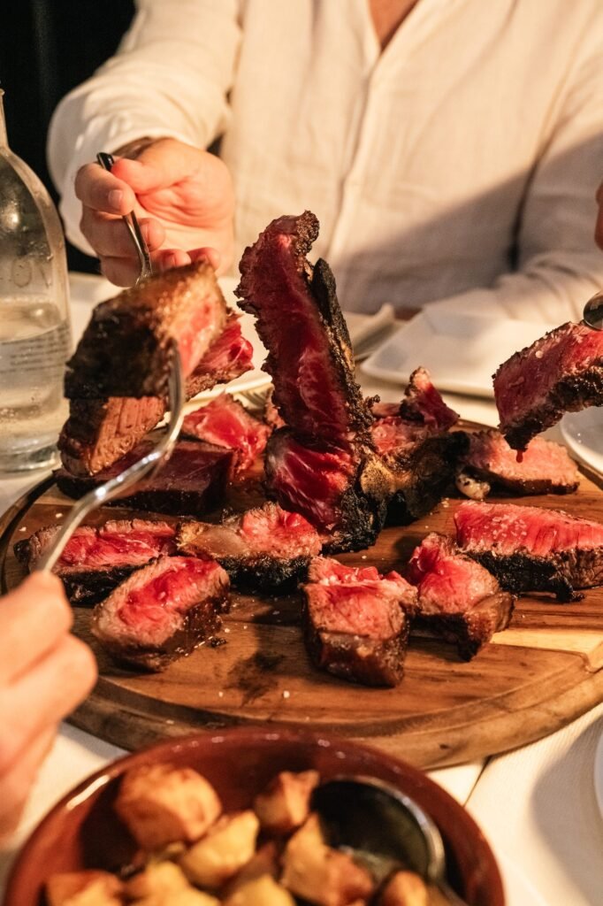 Tagliata di manzo con cuore semi-cotto su un tagliere, condivisa tra amici